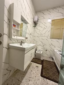 a white bathroom with a sink and a toilet at Beautifully furnished 4 Bedroom Duplex in Lekki +20 photos