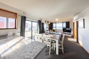 a kitchen and living room with a table and chairs at Waterfront Cottage Bluff in Bluff
