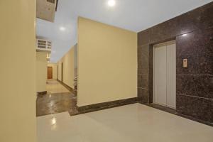 a hallway with a door and a tile wall at Super Collection O Hotel Aqua Villa Near Netaji Subhash Chandra Bose International Airport in Kolkata