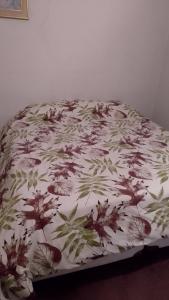 a bed with a floral comforter on top of it at Residencia "Libertad" in San Andrés