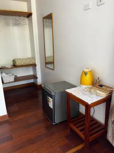 a room with a table and a small table with a yellow vase at Hotel Casablanca in Ollantaytambo