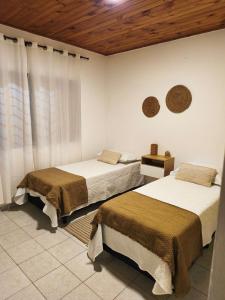 una camera da letto con due letti e soffitto in legno di Alojamiento en Puerto Iguazú, Alojamiento en Cataratas, 2 Habitaciones a Puerto Iguazú