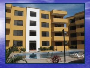 a yellow building with a pool in front of it at Playa Azul in Tonsupa