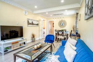 een woonkamer met een blauwe bank en een tafel bij 2 Bedroom East-York bungalow in Toronto