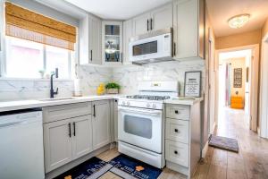 een keuken met witte kasten en een kookplaat oven bij 2 Bedroom East-York bungalow in Toronto