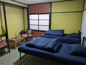 a bedroom with two beds and a table and chairs at Women only B&B KegonFalls in Nikko