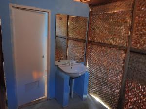 a bathroom with a white sink and a mirror at JN Cottage dan Camping Ground in Karimunjawa