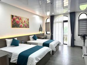 a hotel room with two beds and a window at Sky Night Hotel 2 in Việt Yên