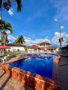 a large pool with blue water in front of a fence at la colombiana casa campestre in Quimbaya