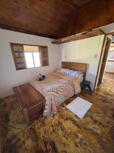 a bedroom with a bed and a table in it at Casinha vista dos sonhos in São Bento do Sapucaí