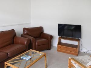 a living room with a couch and a tv at Seashells in Lowestoft
