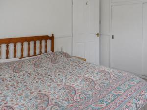 a bedroom with a bed with a blanket on it at Seashells in Lowestoft +4 photos