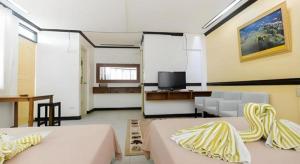 a large room with two beds and a television at Boracay Breeze Resort in Boracay