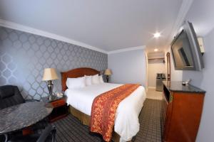 a hotel room with a bed and a flat screen tv at Crystal Lodge Motel in Ventura