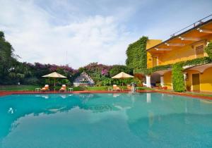 a large swimming pool with chairs and umbrellas at HMB Guadalajara Centro in Guadalajara