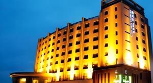 a large building with a lit up building at Yinchuan Ningdong Aolisheng Fern Boutique Hotel in Maliantai