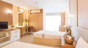 a hotel room with a bed and a desk at Clef Hotel Bangkok in Ban Khlong Samrong