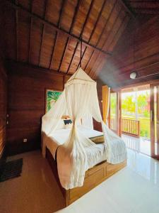 a bedroom with a bed with a mosquito net at Bamboo Bungalow Jungle View in Nusa Penida