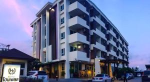a large building with cars parked in front of it at Home Place Lopburi Hotel in Lop Buri