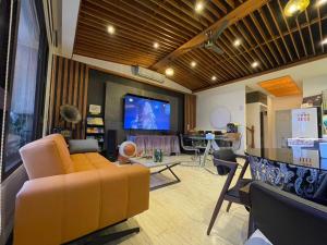 a living room with a yellow couch and a tv at Love's World B&B in Ji'an