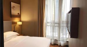 a bedroom with a bed and a large window at JTOUR Inn Huangshi North Station Cihu Scenic Area in Huangshigang