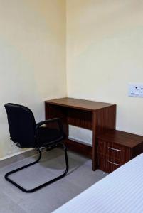 una silla negra sentada frente a un escritorio en Aathidya Lodge, en Ādoni