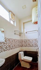 un baño con inodoro y lavabo en Aathidya Lodge, en Ādoni