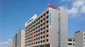 a tall white building with a sign on it at City Comfort Inn Dongguan Gaobu Avenue in Dongguan