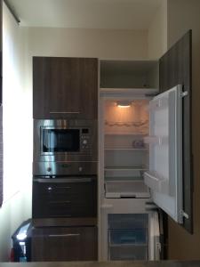 a kitchen with an open refrigerator and a microwave at Palme d'hote in Cannes