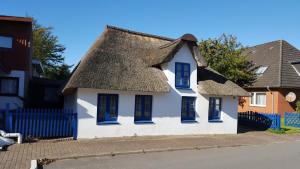 uma casa branca com telhado de palha em Holiday Homes Buchholz em Büsum