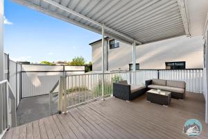 a patio with a couch and chairs on a deck at Spacious 4 Bedroom House Near Station & Parramatta in Guildford