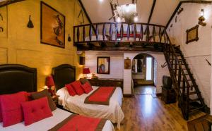 een slaapkamer met 2 bedden en een wenteltrap bij Hosteria Rumipamba De Las Rosas in San Miguel de Salcedo