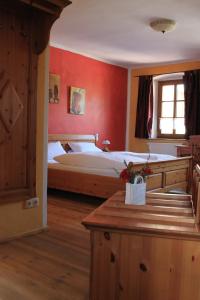 PressathにあるLandhotel Kahrmühleの赤い壁のベッドルーム1室(大型ベッド1台付)