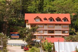 un edificio con techo naranja en una montaña en Hotel Heidinger, en Oxapampa