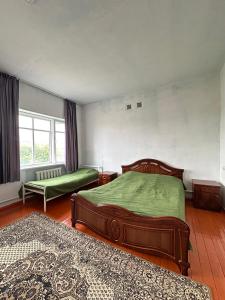 a bedroom with two beds and a window at Коломто in Bokonbayevo