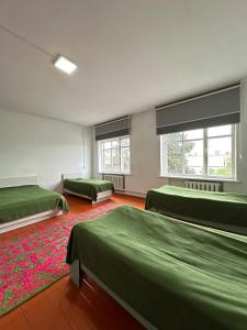 a room with two beds and a red carpet at Коломто in Bokonbayevo +8 photos