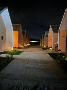 an empty road in front of a row of houses at night at Fandee suites in Ban Sa Kut