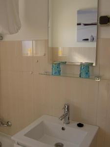 a white bathroom with a sink and a mirror at Quartos Com Boas Vistas in Ribeira da Gafa