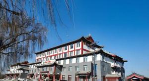 a large white and red building on a street at Vienna Hotel Shandong Qufu Sankong Landscape in Jining