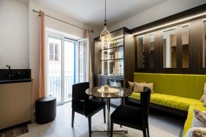 a living room with a yellow couch and a table at Cielo | Suite con Bagno e Cucina Condivisa – Centrale in Polignano a Mare