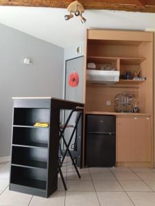 a kitchen with a black desk and a shelf at Appartement Chasseneuil Futuroscope in Chasseneuil-du-Poitou