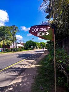 a sign for coconut beach on the side of the road at Coconut Beach in Talalla