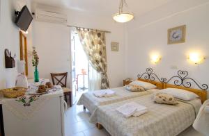 Un dormitorio con 2 camas y una mesa con toallas. en Pension Hlias - Chora Amorgos, en Amorgós