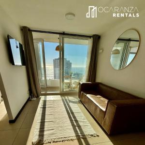 a living room with a couch and a large window at Hermoso Depto sector Enjoy in Coquimbo