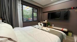 une chambre avec un lit avec des cygnes dessus dans l'établissement Thank Inn Hotel Zhejiang Ningbo Haishu Yinzhou Avenue Metro Station, à Ningbo