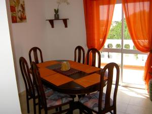 a dining room table and chairs in a room with a window at Quartos Com Boas Vistas in Ribeira da Gafa