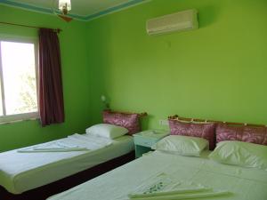 A bed or beds in a room at Mandalinn Hotel