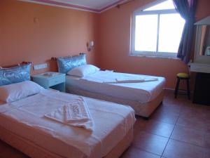 A bed or beds in a room at Mandalinn Hotel