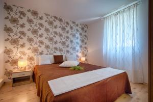 a bedroom with a large bed with a brown blanket at Apartments Perla in Rukavac