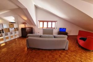a living room with a white couch and a red chair at Casa Michetti in Castel di Sangro